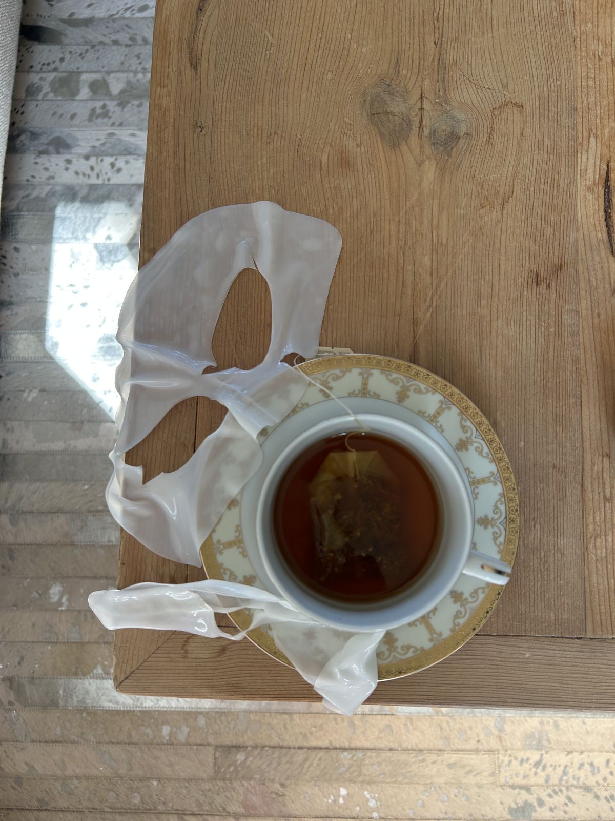 Eine Tasse Tee und eine Tuchmaske auf einem Holztisch